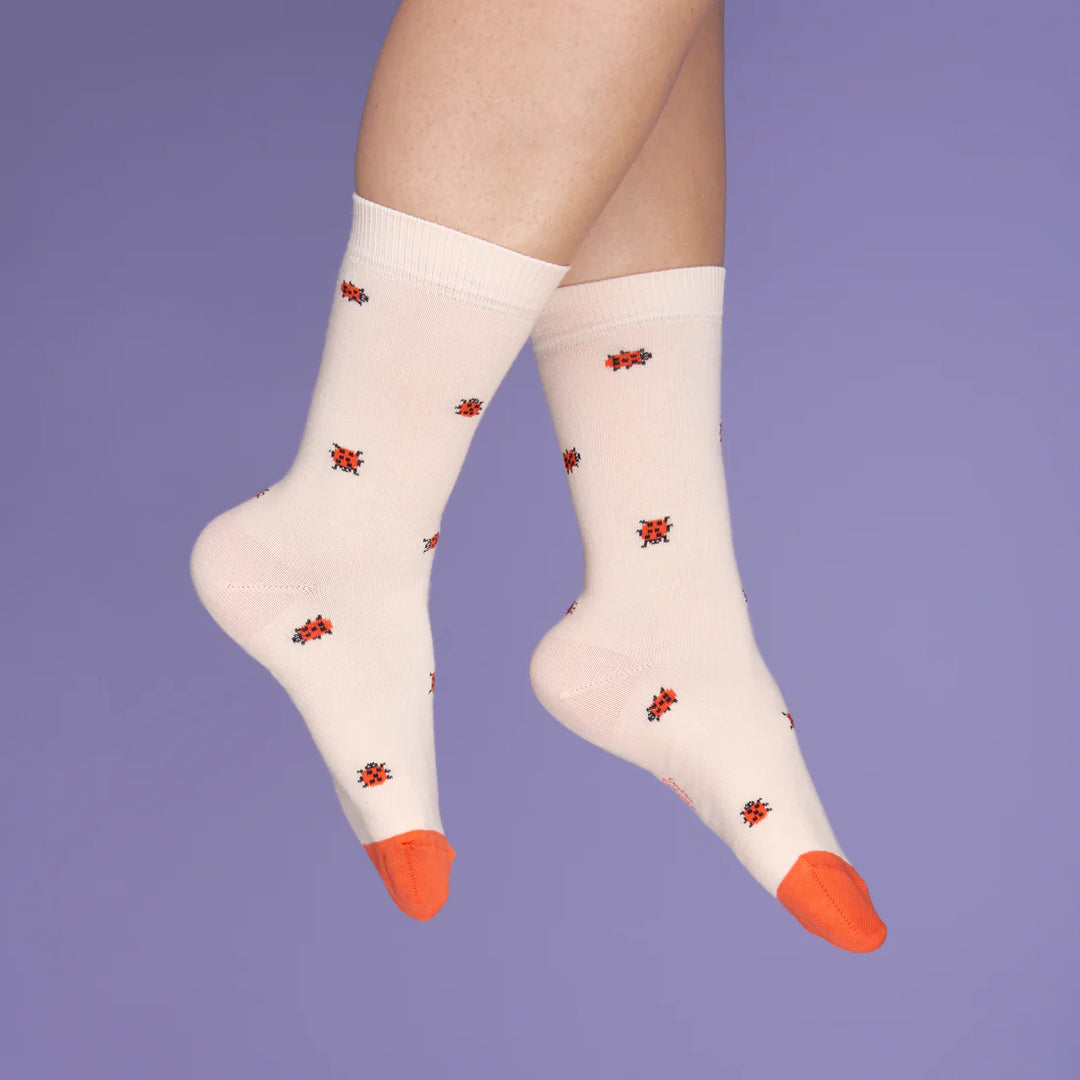 Ladybug Socks von Coucou Suzette - getragen vor lila Hintergrund