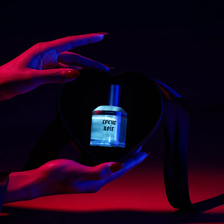 Heretic Parfum Coeur Noir Eau de Parfum in stimmungsvoller Inszenierung mit farbigem Licht