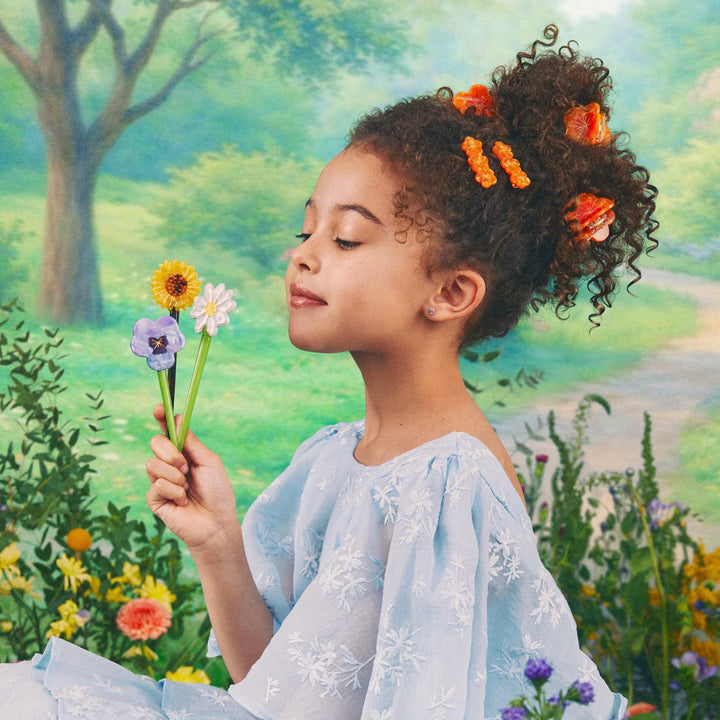Sunflower Hair Stick von Coucou Suzette - Model im Profil mit Haarspangen im Haar und verschiedene Haarstäbe als Blumenstrauß in der Hand