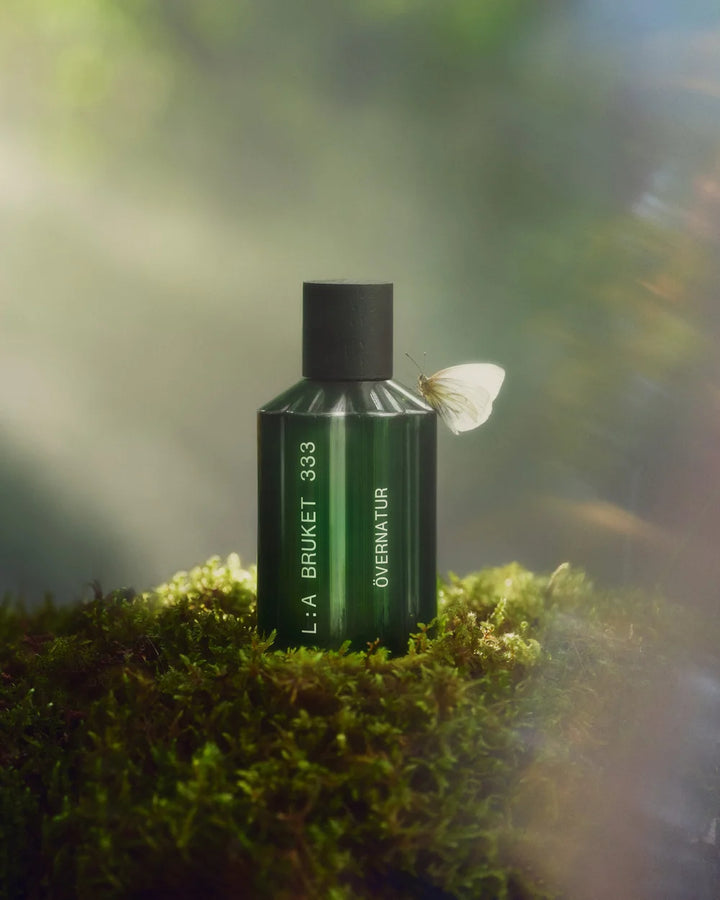L:A Bruket Övernatur Eau de Parfum auf moosbewachsenem Waldboden im weichen Sonnenlicht