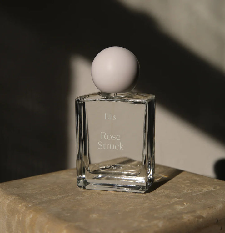 Liis Rose Struck Eau de Parfum Flakon in dunkler, stimmungsvoller Inszenierung auf Stein