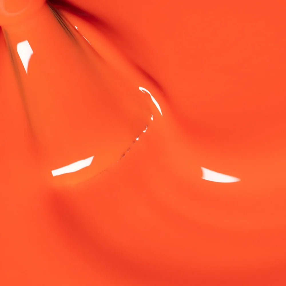 Nahaufnahme des Manucurist Sunset Nagellackpinsels, der die leuchtende korall-orange Formel und glatte Auftragstextur vor passendem orangem Hintergrund zeigt