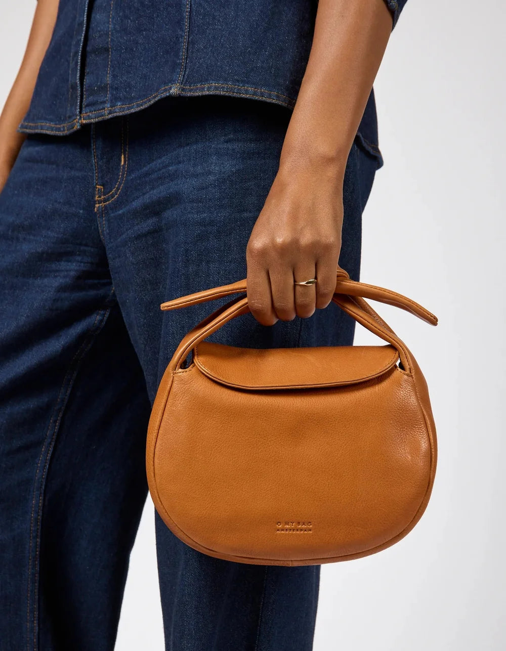 O My Bag Coco Croissant als kleine braune Handtasche am Arm getragen