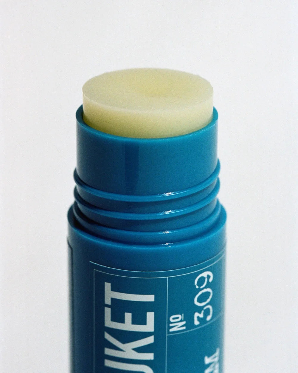 Geöffneter L:A Bruket SOS Lip Balm mit hellgelbem Balsam und cremiger Textur