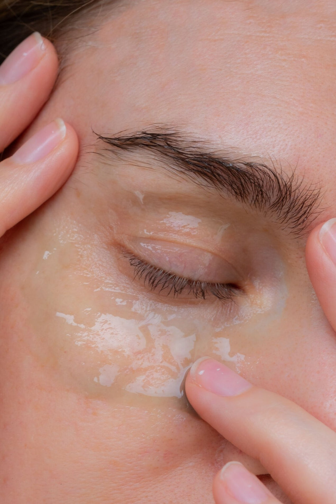 Model trägt NAYA Cell Resilience Serum auf die Augenpartie auf