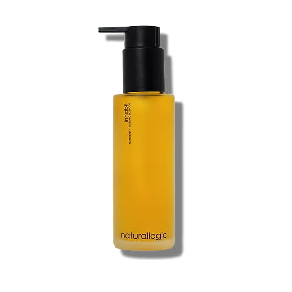 Freisteller: Naturallogic Inhabit Body Oil – gelbe Glasflasche mit schwarzem Pumpspender