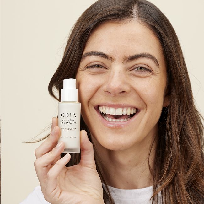 Model hält ODEN La Crème Hydratante in der Hand – Portraitfoto