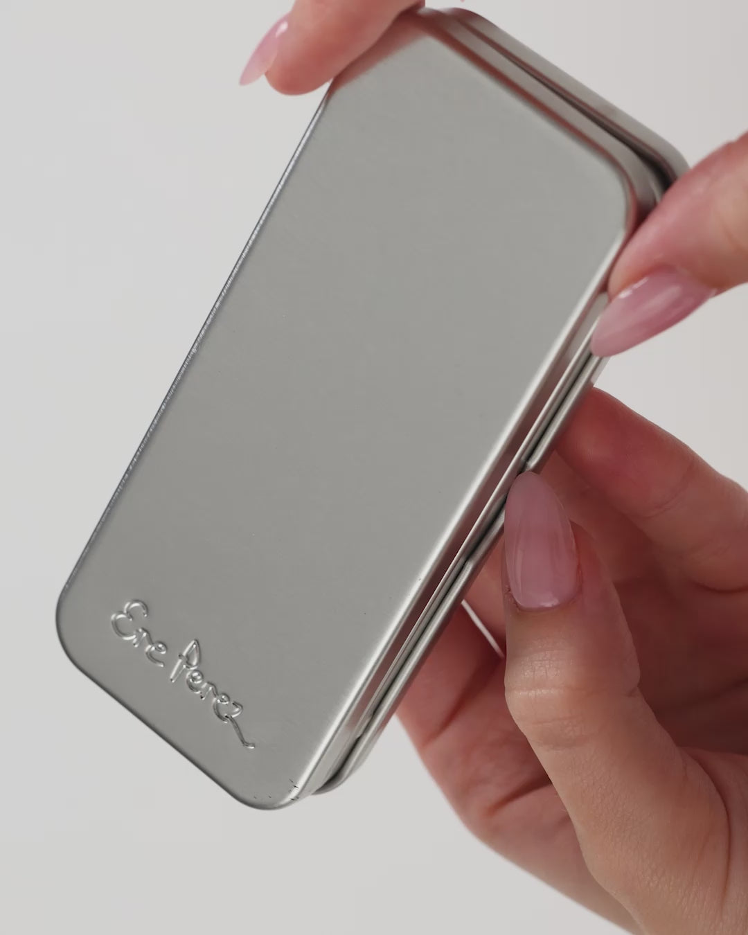Nachfüllbares silberfarbenes Metalletui der Ere Perez Chamomile Eye Palette in der Hand gehalten