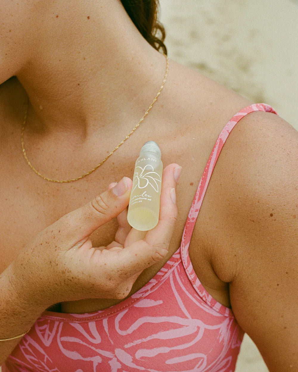 Leahlani Perfume Oil – Rollerball-Flakon am Dekolleté, Lifestyle am Strand